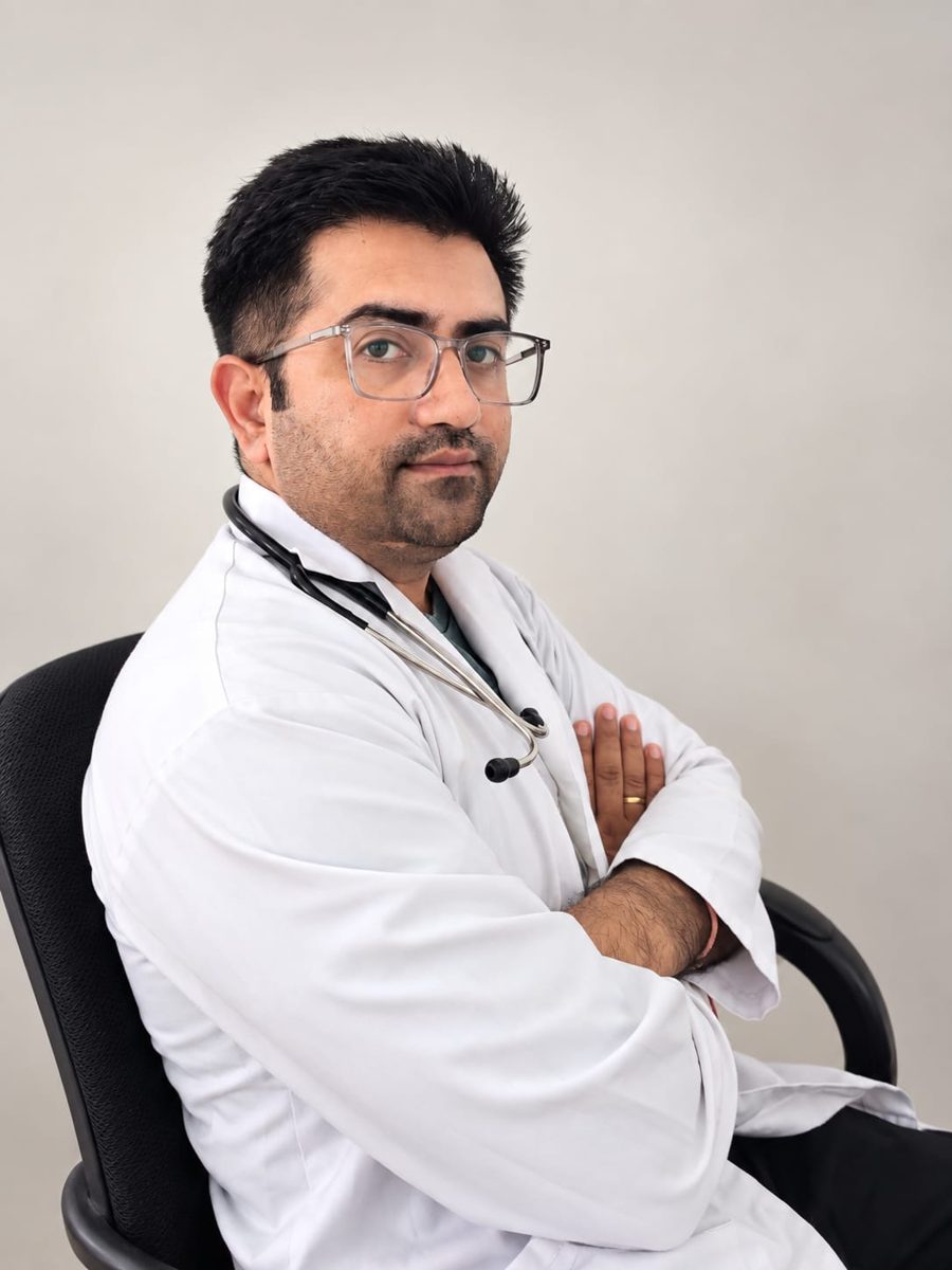 Dr. Pardeuman Singh seated in a white coat